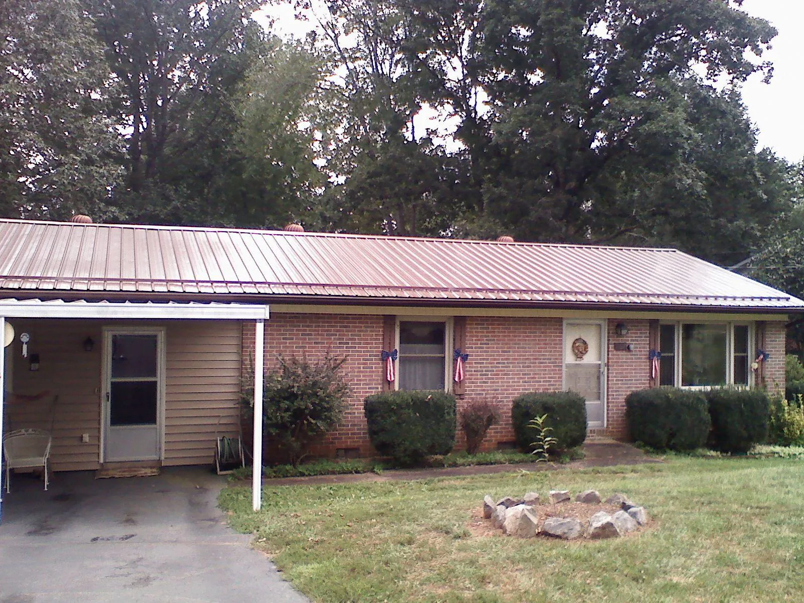Bronze metal roof and carport on a brick ranch home — Roof Repair work by our crew in Delhi